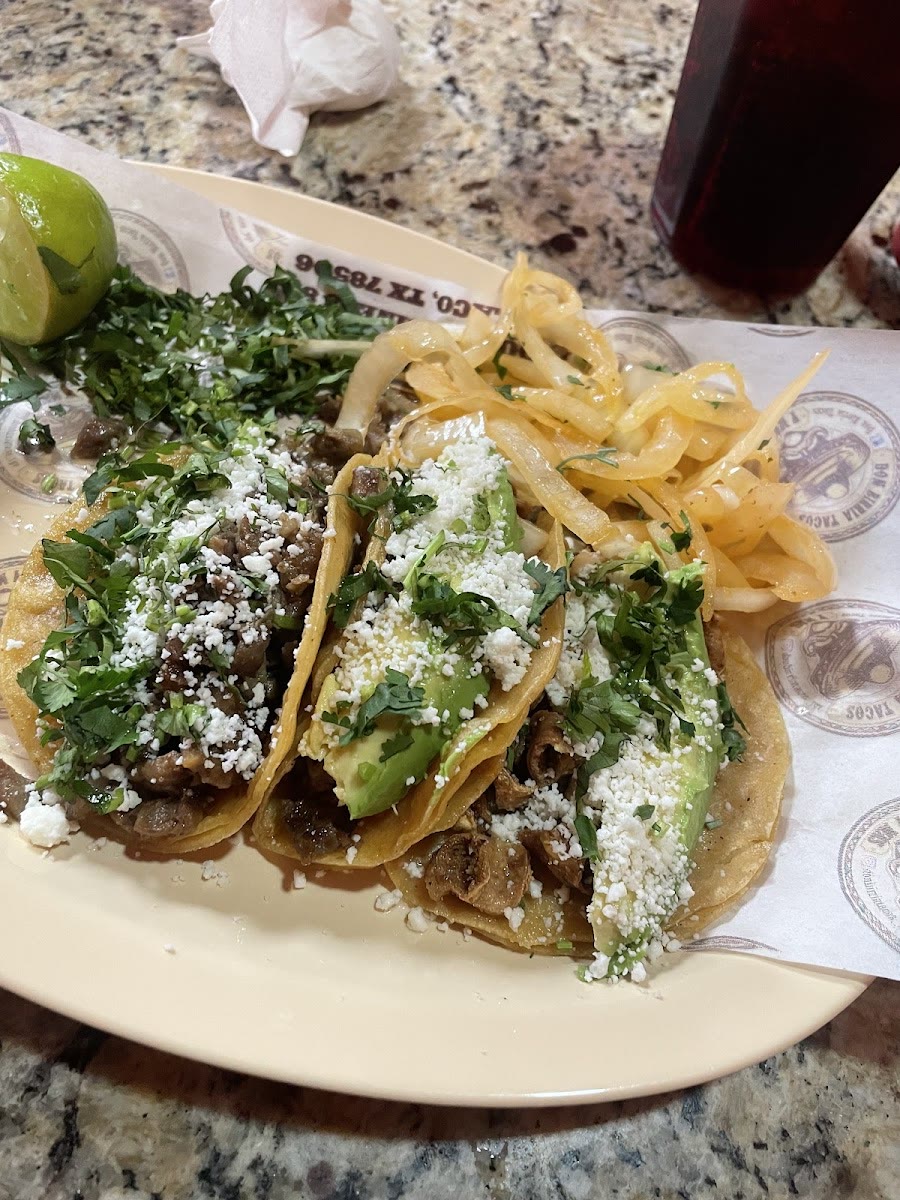 Tacos pirata loaded with cilantro, queso and grilled onion